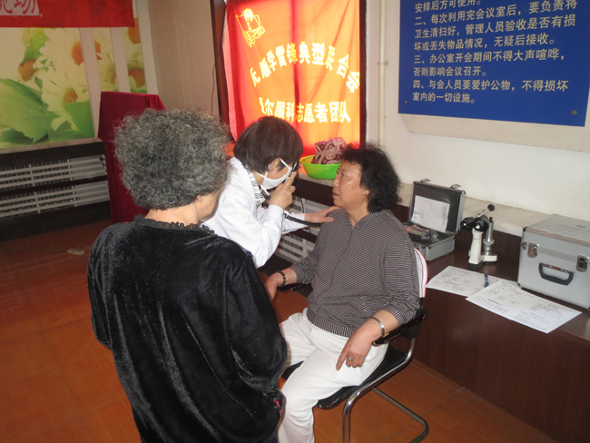 眼病医院志愿者为社区妇女检查眼疾